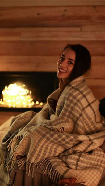 frau kuschelt vor kamin 340x600